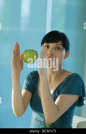 Apple floating in air between woman's hands Stock Photo