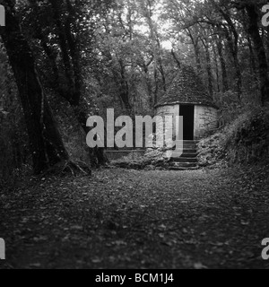 Small stone building in woods, black and white Stock Photo