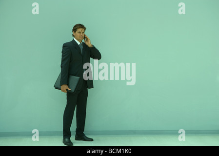 Buisnessman holding cell phone to ear, full length Stock Photo