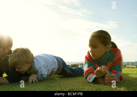 Three kids lying on grass Stock Photo