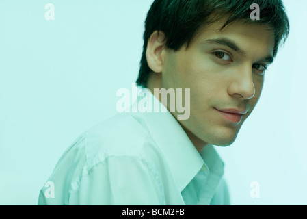 Young man looking over shoulder at camera, portrait Stock Photo