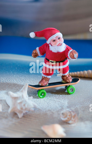 Santa Claus figurine skateboarding on beach Stock Photo