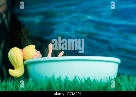 Doll relaxing in hot tub Stock Photo