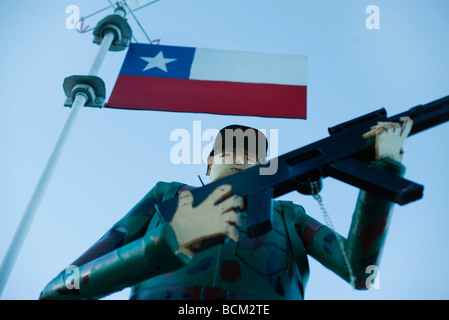 Soldier figurine holding rifle beneath Chilean flag Stock Photo