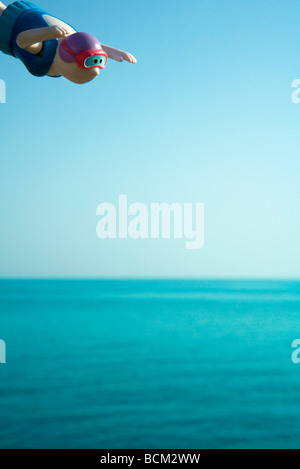 Toy diver poised over sea Stock Photo