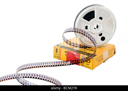 An old 8mm Kodachrome colour movie film reel with film unrolled perched on top of the original yellow film box. Stock Photo