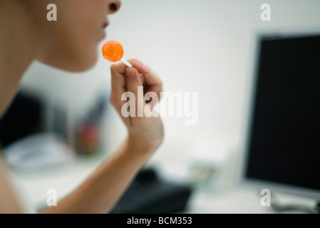 Young woman holding lollipop, cropped view Stock Photo