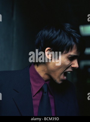 Man in suit yelling, side view Stock Photo