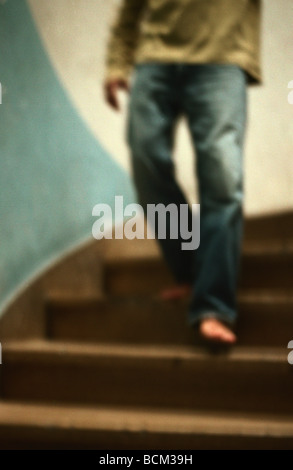 Man walking down stairs, waist down, defocused Stock Photo