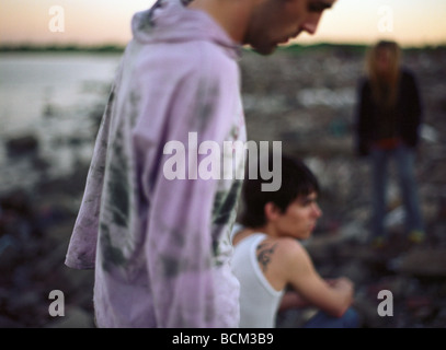 Young adults on rocky shore Stock Photo