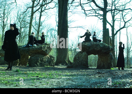 Women dressed as spies, using telephones in woods Stock Photo