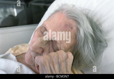 Elderly woman resting head on hand Stock Photo