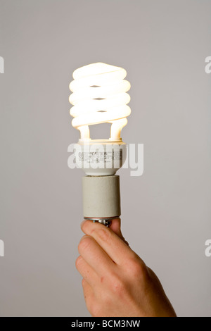 Hand holding a new Energy efficient Compact fluorescent lightbulb Stock Photo