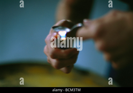Person heating illegal drug in spoon Stock Photo