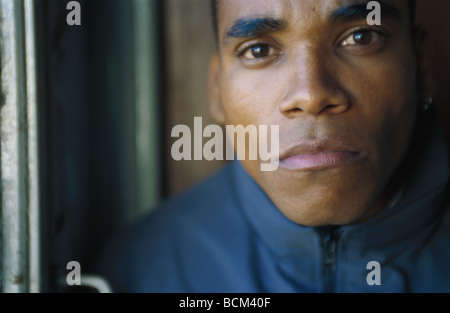 Young man looking at camera with serious expression, close-up, portrait Stock Photo