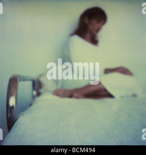 Woman sitting on hospital bed, blurred Stock Photo