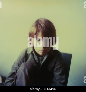 Boy sitting in chair, leaning forward and looking at camera, portrait Stock Photo