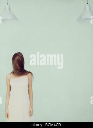 Young woman standing with face wrapped in hair Stock Photo