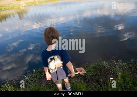 picture with a fish net in the water, a human hand trying to catch a fish,  fishing that leisure concept Stock Photo - Alamy