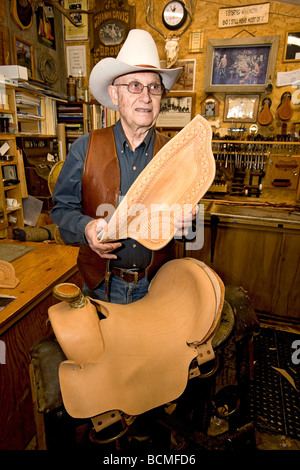 Glen Thompson, elderly saddle maker shows off one of his hand made saddles in his shop in Eden, Utah Stock Photo