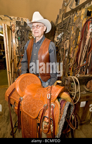 Glen Thompson, elderly saddle maker shows off one of his hand made saddles in his shop in Eden, Utah Stock Photo