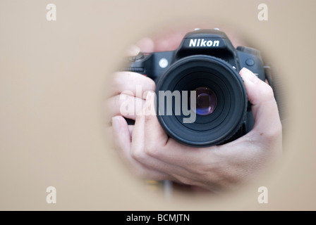 woman photographer taking photographs with her Nikon digital camera  in studio Stock Photo