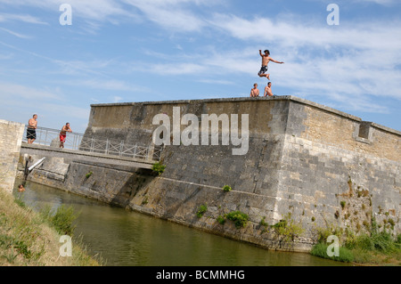 Stock photo of boys leaping from the city walls on the ile d'oleron in France and landing in the sea Good fun or what Stock Photo