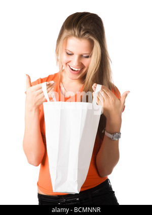 Young smiling woman looking into shopping bag Isolated on white Stock Photo