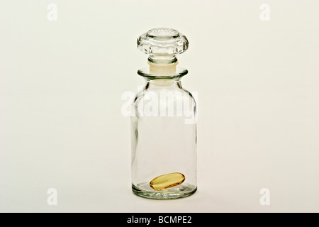 Single vitamin pill inside an old fashioned apothecary bottle. Stock Photo