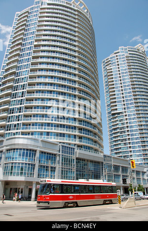 A streetcar in Toronto passing one of the many condominiums  built in recent years in harbourfront on the city's waterfront. Stock Photo