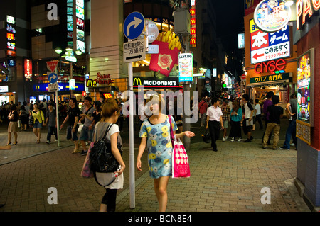 Pedestrians at a bustling shopping street in Shibuya district Tokyo Japan Stock Photo