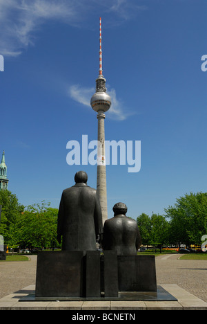 Berlin Germany Staue of Karl Marx right Friedrich Engels on Marx Engels Forum facing the Furnsehturm TV tower on Alexanderplatz Stock Photo