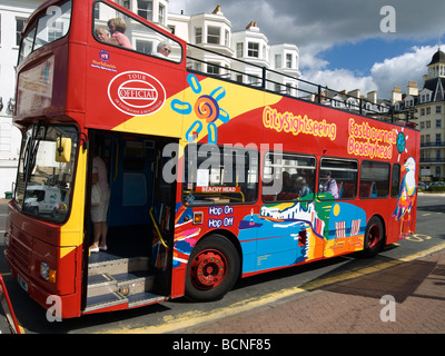 A red open topped tourist bus running between Eastbourne and Beachy Head Stock Photo