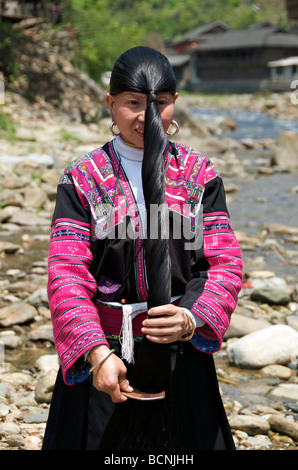 Yao Long Hair woman combing hair beside river Huangluo Village Guangxi China Stock Photo