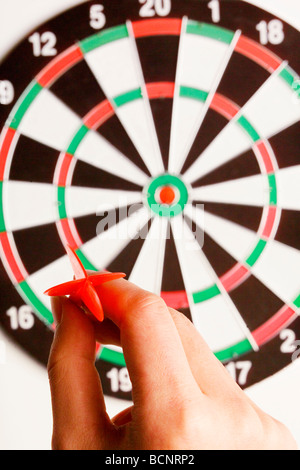 Hand throwing dart toward target Stock Photo