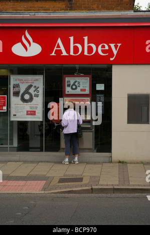 Abbey Bank Branch with a Woman at A Cashpoint Stock Photo