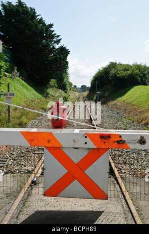 Manually operated level crossing barrier with paraffin warning lamp light across a train railway track Stock Photo