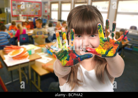 Young School Age Child Painting With Her Hands in Class Stock Photo