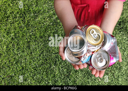 Aluminum Cans Crushed For Recycling in a Childs Hands Stock Photo