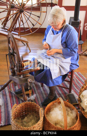 Costumed interpreter spins yarn at East Family Sisters Shop at Shaker Village of Pleasant Hill Harrodsburg Kentucky Stock Photo