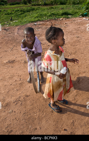 Two children on red earth street in Kampala slum Stock Photo