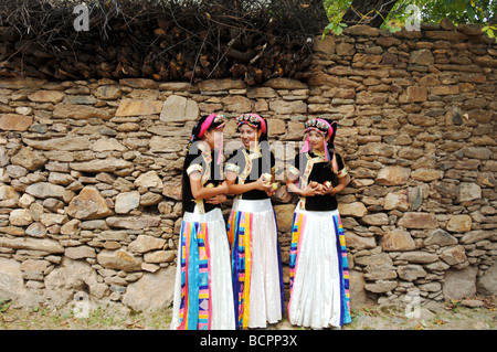 Three smiling Jiarong Tibetan young women wearing traditional headdress and rainbow colored skirt in Gyarong Beauty Valley, Stock Photo