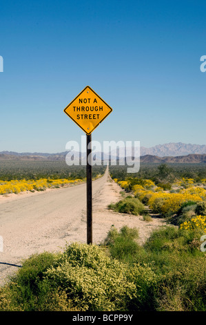 Sign along long desert road Stock Photo