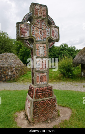 Ornate painted celtic cross with a depictino of Saint Patrick in the centre,at a monastic village in the Irish National Heritage Park, County Wexford. Stock Photo