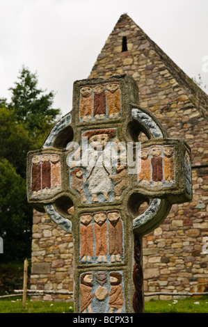 Ornate painted celtic cross with a depictino of Saint Patrick in the centre,at a monastic village in the Irish National Heritage Park, County Wexford. Stock Photo