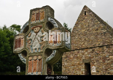 Ornate painted celtic cross with a depictino of Saint Patrick in the centre,at a monastic village in the Irish National Heritage Park, County Wexford. Stock Photo