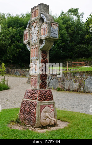 Ornate painted celtic cross with a depictino of Saint Patrick in the centre,at a monastic village in the Irish National Heritage Park, County Wexford. Stock Photo