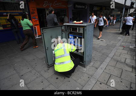 A siemens telephone engineer at work on a junction box in brighton Stock Photo