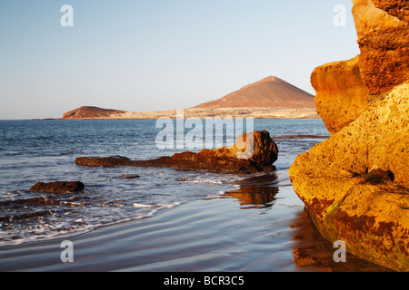 El Medano beach on Tenerife in The Canary Islands. Montaña Roja (red mountain) in the distance Stock Photo