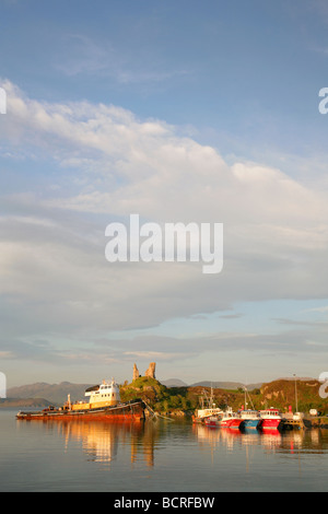 Tug boat and small fishing boats moored at sunset by Castle Moil, Kyleakin, Isle of Skye, Scotland. Stock Photo